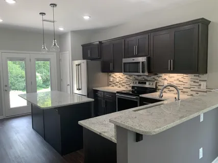 a kitchen with granite countertop cabinets appliances and a wooden floor