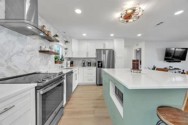 a kitchen with a sink stainless steel appliances furniture and a window