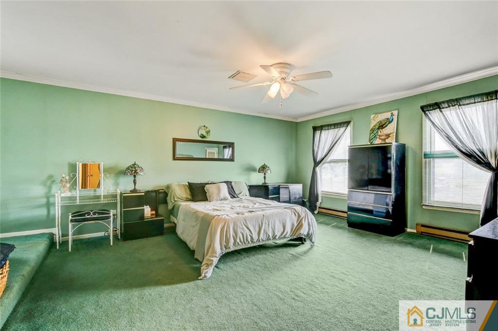 22 Cottrell Road Old Bridge, NJ 07747 - Photo 20 of 32 a spacious bedroom with a bed and a flat tv screen on dresser