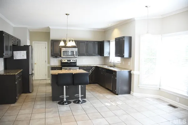 a kitchen with stainless steel appliances granite countertop a stove top oven a sink a counter top space and cabinets