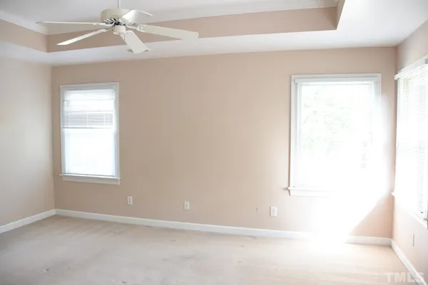 an empty room with a window and a fan