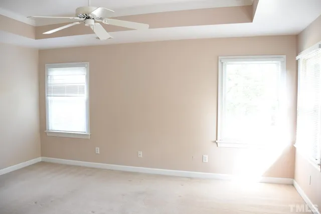 an empty room with a window and a fan