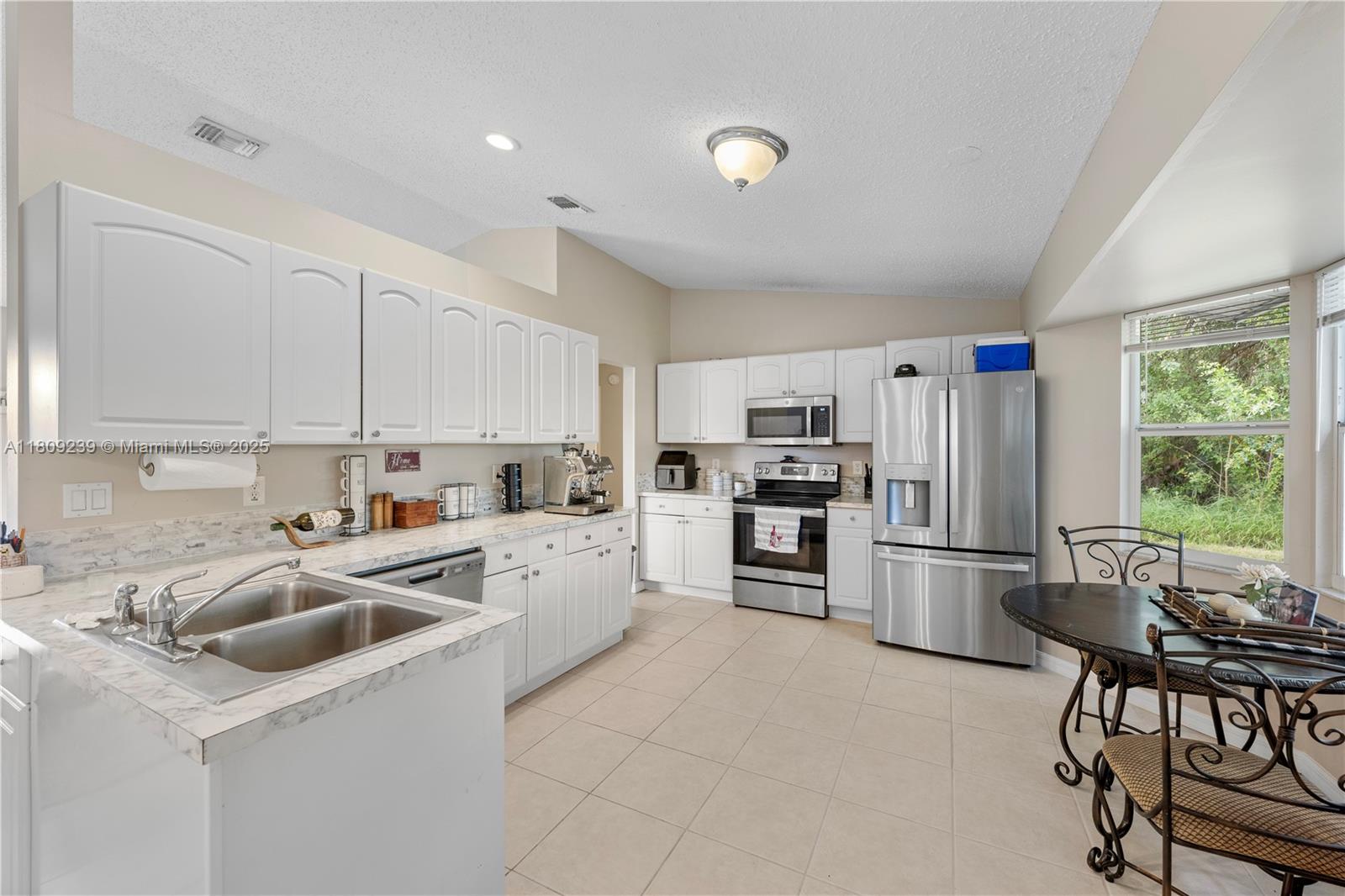2330 Southwest Lejune Street Port St. Lucie, FL 34953 - Photo 6 of 20 a kitchen that has a lot of cabinets a sink and appliances