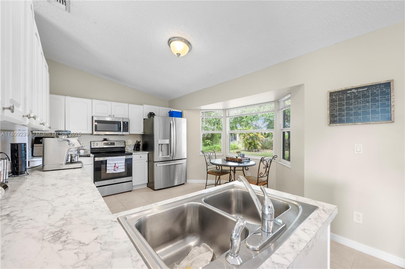 2330 Southwest Lejune Street Port St. Lucie, FL 34953 - Photo 9 of 20 a kitchen with a stove a sink and a refrigerator