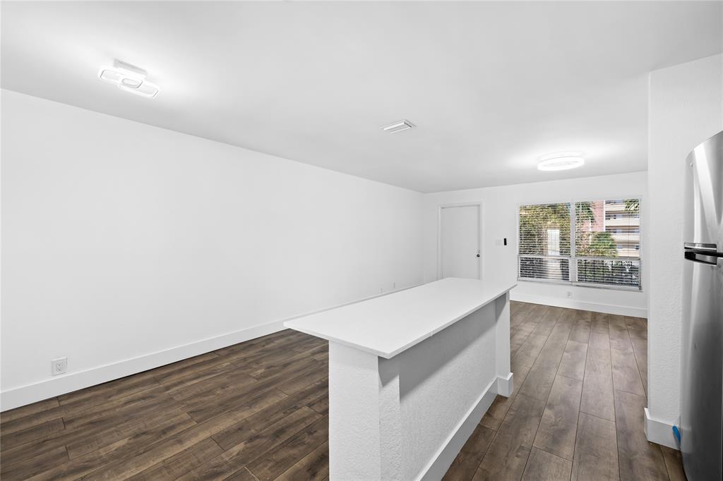 1100 Crystal Lake Drive, Unit 209 Deerfield Beach, FL 33073 - Photo 11 of 34 a view of an empty room with wooden floor and a window
