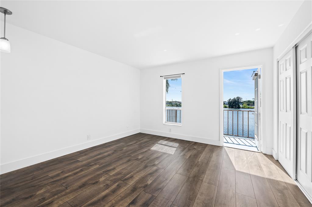 1100 Crystal Lake Drive, Unit 209 Deerfield Beach, FL 33073 - Photo 16 of 34 an empty room with wooden floor and windows
