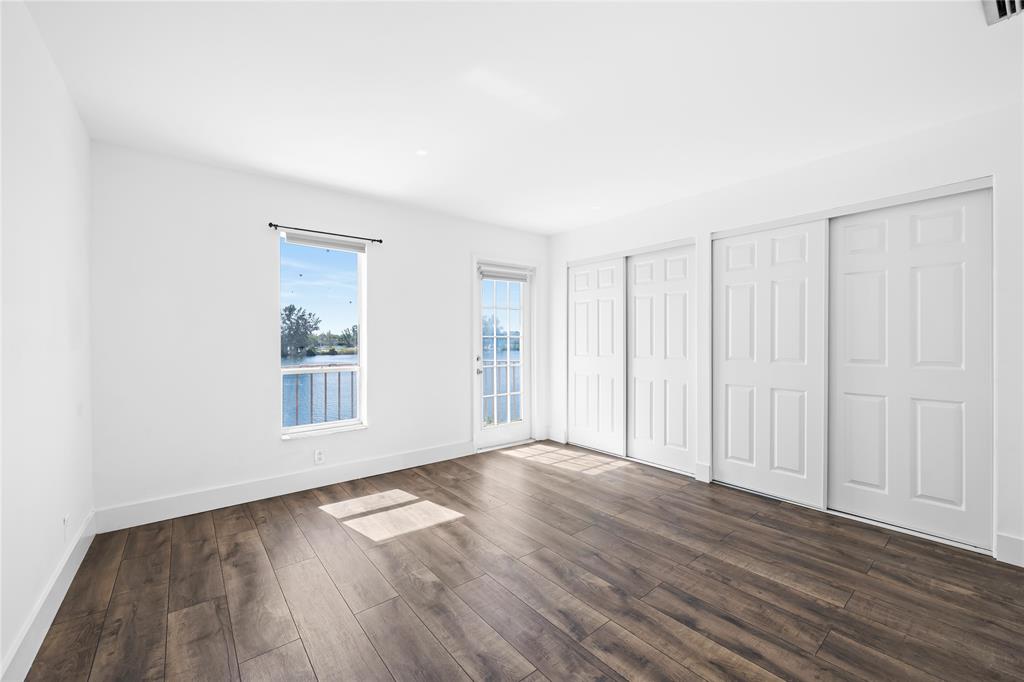 1100 Crystal Lake Drive, Unit 209 Deerfield Beach, FL 33073 - Photo 18 of 34 a view of an empty room with wooden floor and a window