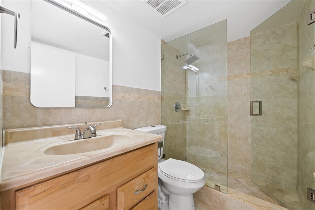 1100 Crystal Lake Drive, Unit 209 Deerfield Beach, FL 33073 - Photo 20 of 34 a bathroom with a sink a toilet and shower