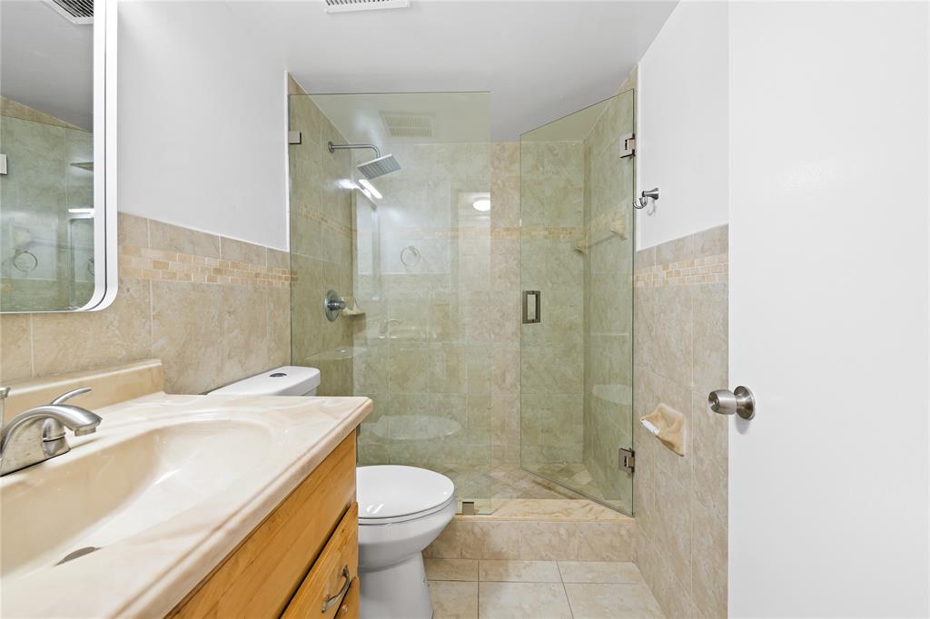 1100 Crystal Lake Drive, Unit 209 Deerfield Beach, FL 33073 - Photo 21 of 34 a bathroom with a sink a toilet and shower