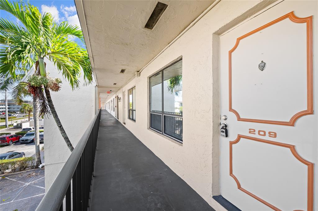 1100 Crystal Lake Drive, Unit 209 Deerfield Beach, FL 33073 - Photo 22 of 34 a view of a hallway with furniture
