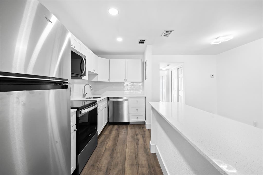 1100 Crystal Lake Drive, Unit 209 Deerfield Beach, FL 33073 - Photo 8 of 34 a kitchen with a refrigerator a sink and wooden floor