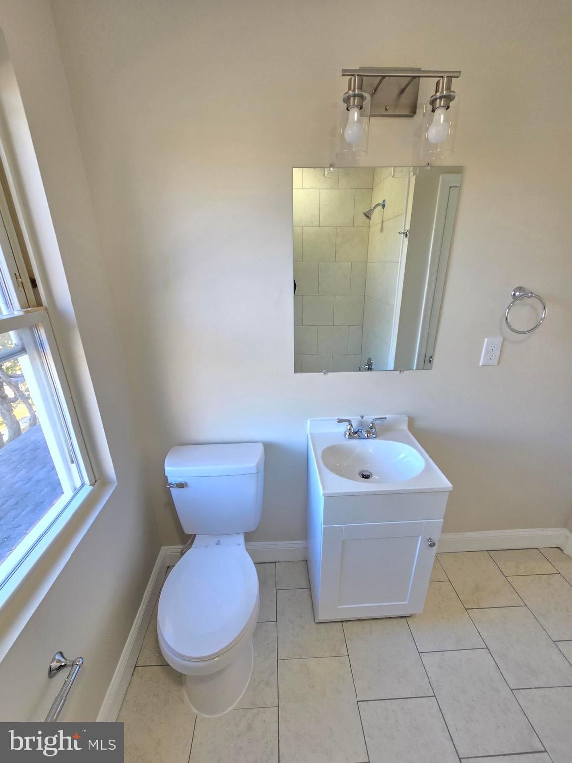 3838 Greenspring Avenue Baltimore, MD 21211 - Photo 11 of 23 a bathroom with a toilet sink and mirror