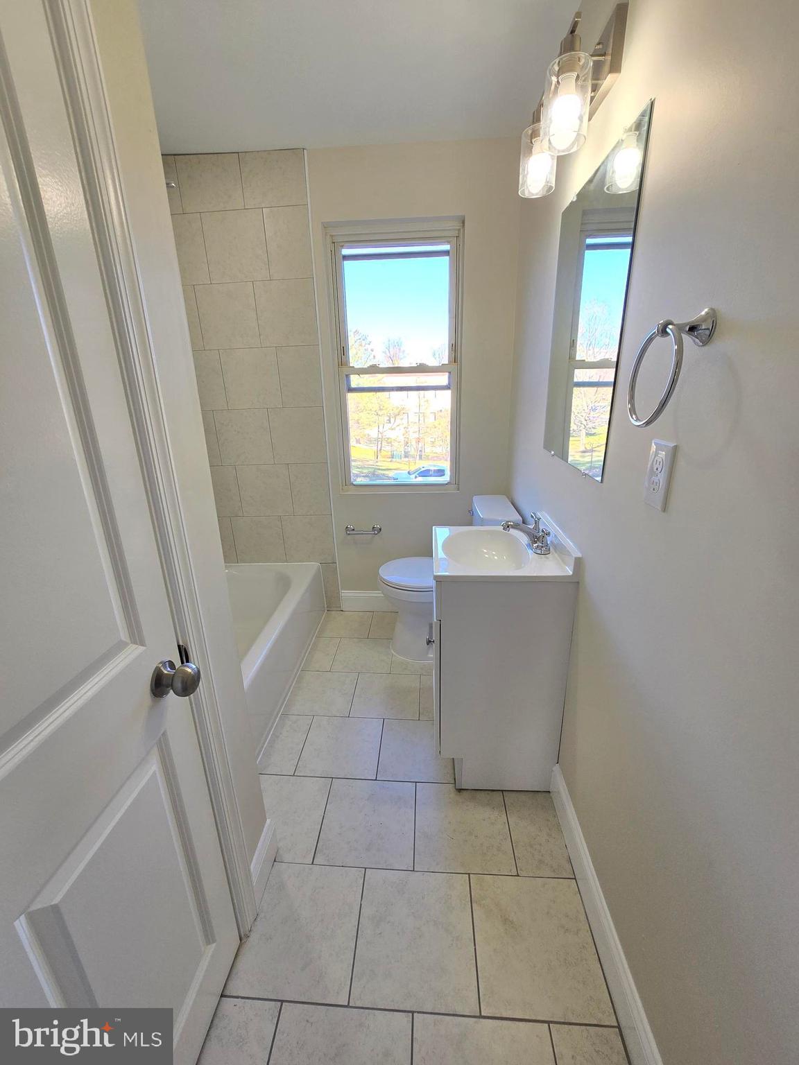 3838 Greenspring Avenue Baltimore, MD 21211 - Photo 12 of 23 a bathroom with a sink a vanity and a mirror