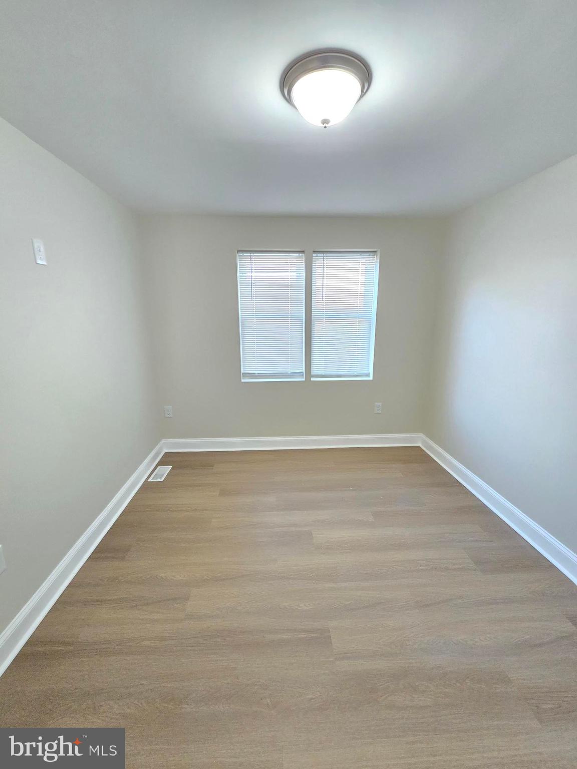 3838 Greenspring Avenue Baltimore, MD 21211 - Photo 13 of 23 an empty room with wooden floor and windows