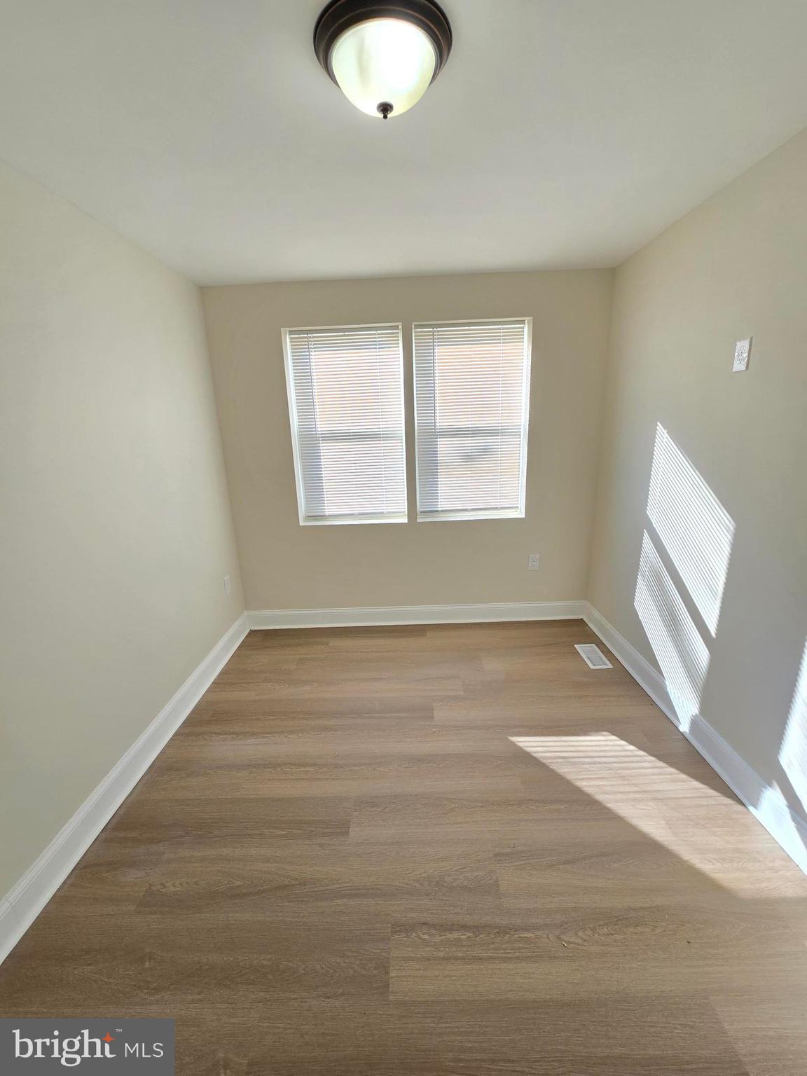 3838 Greenspring Avenue Baltimore, MD 21211 - Photo 15 of 23 an empty room with wooden floor and windows