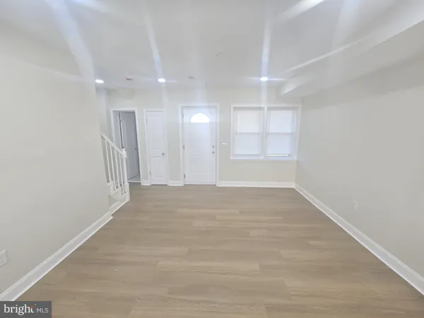 a kitchen with a sink and wooden floor