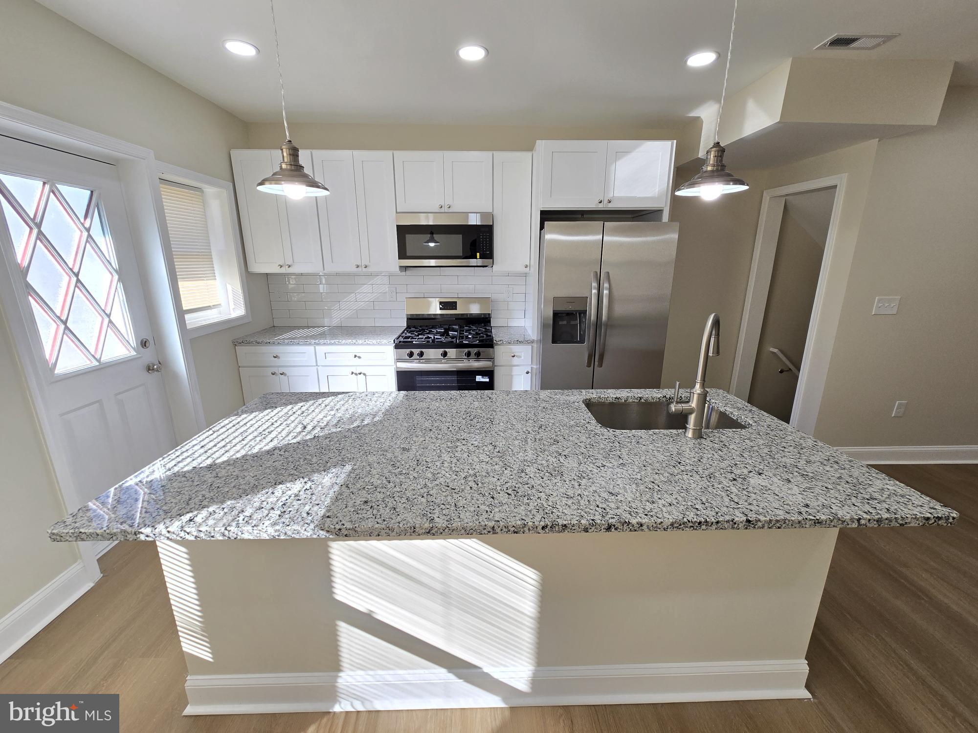 3838 Greenspring Avenue Baltimore, MD 21211 - Photo 7 of 23 a kitchen with stainless steel appliances granite countertop a sink refrigerator and microwave