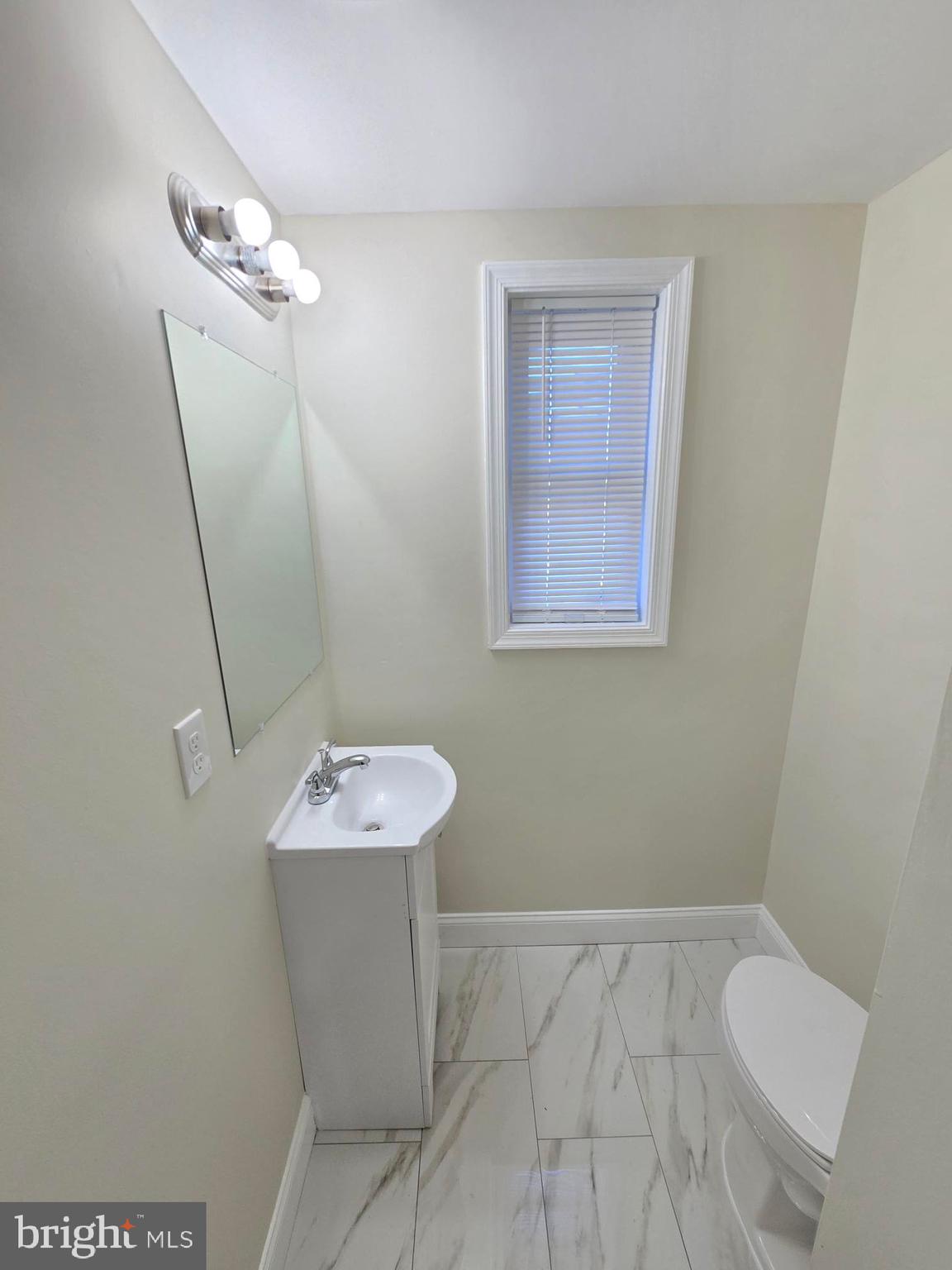 3838 Greenspring Avenue Baltimore, MD 21211 - Photo 8 of 23 a bathroom with a sink a toilet and a mirror