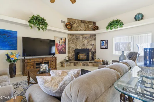 a living room with furniture a flat screen tv and a fireplace