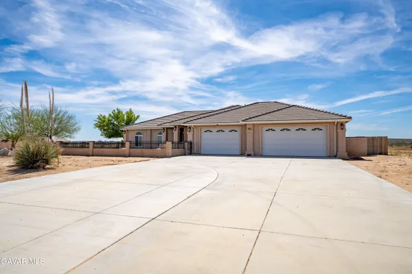 a front view of a house with a garden and trees