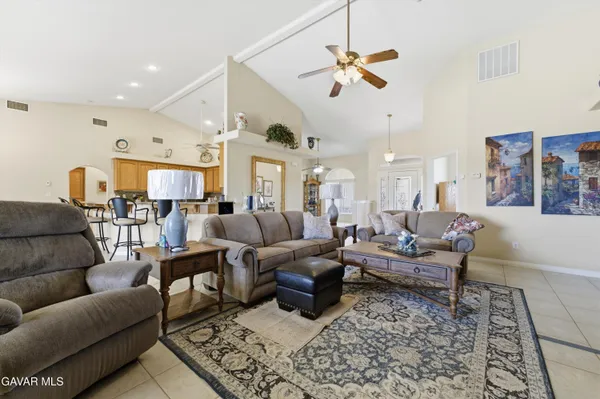 a living room with furniture kitchen view and a chandelier