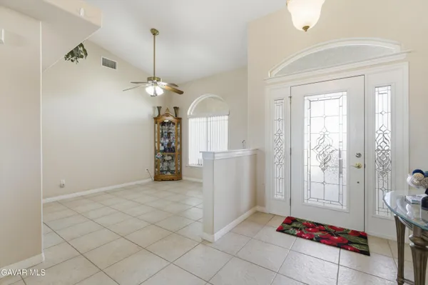 a view of a room with a chandelier fan and windows