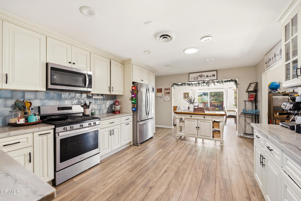 616 Island View Street Fillmore, CA 93015 - Photo 6 of 57 a kitchen with stainless steel appliances a white stove top oven a sink dishwasher and a refrigerator with wooden floor