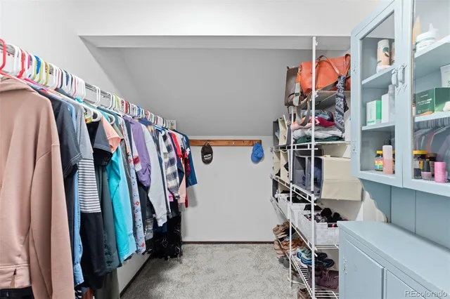 a view of walk in closet with clothes and shoes