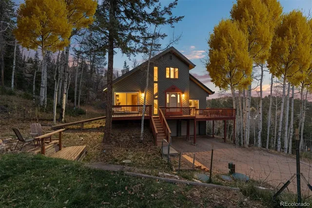 a view of house with backyard and trees
