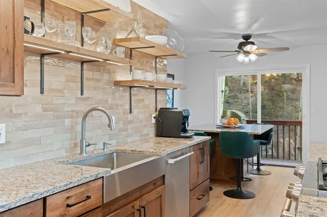 a view of a kitchen with a sink a kitchen island a stove and a window