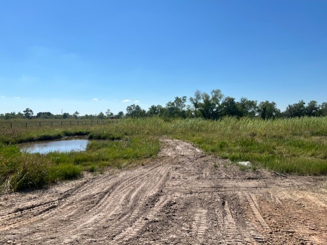 22099 Sattler Road Winnie, TX 77665 - Photo 20 of 20 a view of a lake with green field