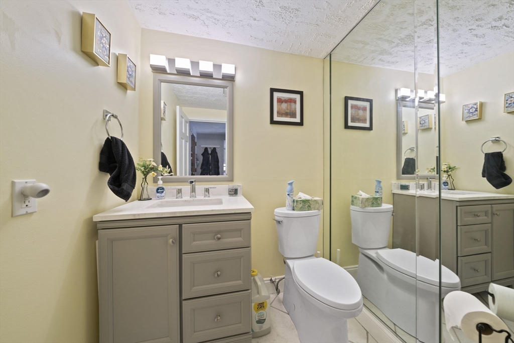 9 Broadway, Unit 305 Saugus, MA 01906 - Photo 12 of 32 a bathroom with a toilet sink and mirror