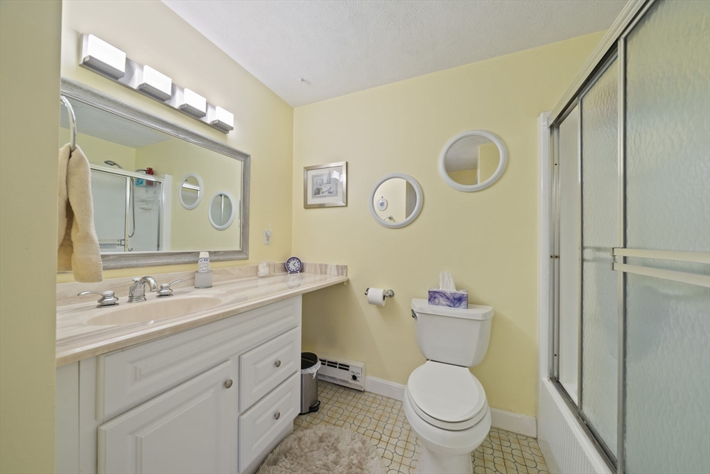 9 Broadway, Unit 305 Saugus, MA 01906 - Photo 20 of 32 a bathroom with a toilet sink vanity and mirror