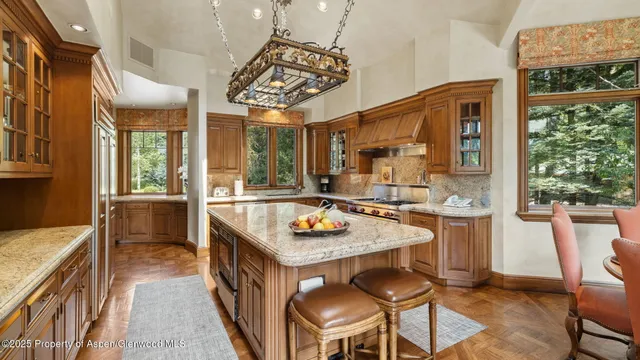 a kitchen with stainless steel appliances granite countertop a stove a sink and a refrigerator with wooden floor
