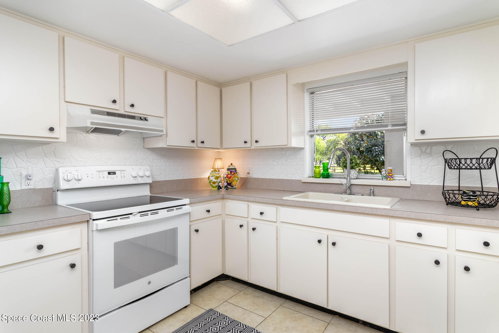 2095 Montgomery Road Melbourne, FL 32935 - Photo 11 of 25 a kitchen with white cabinets white appliances and sink