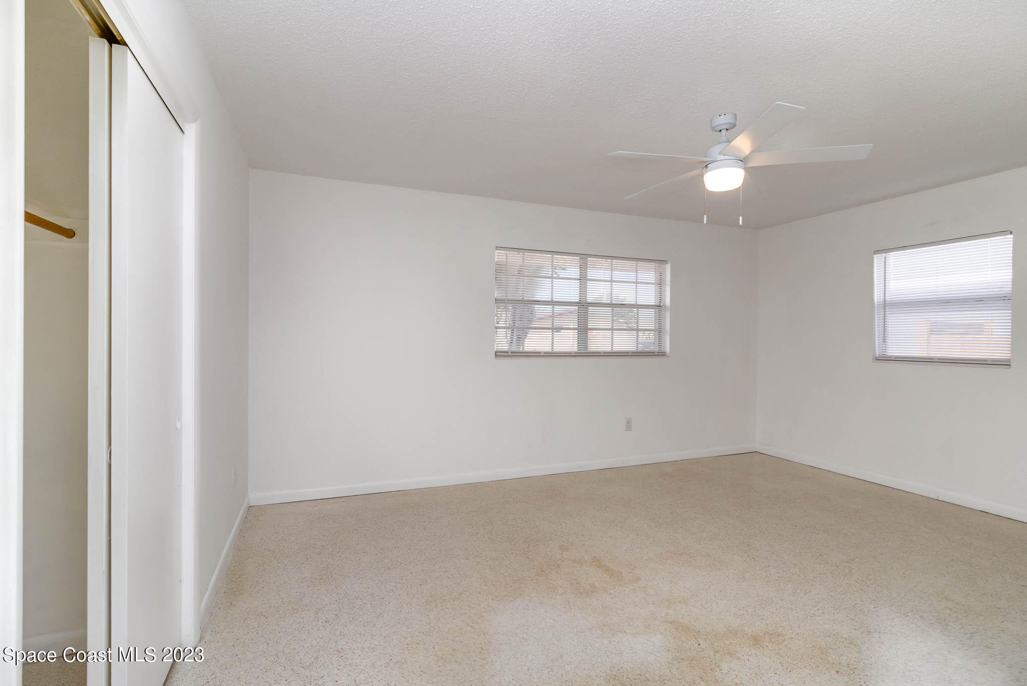 2095 Montgomery Road Melbourne, FL 32935 - Photo 19 of 25 an empty room with windows and ceiling fan