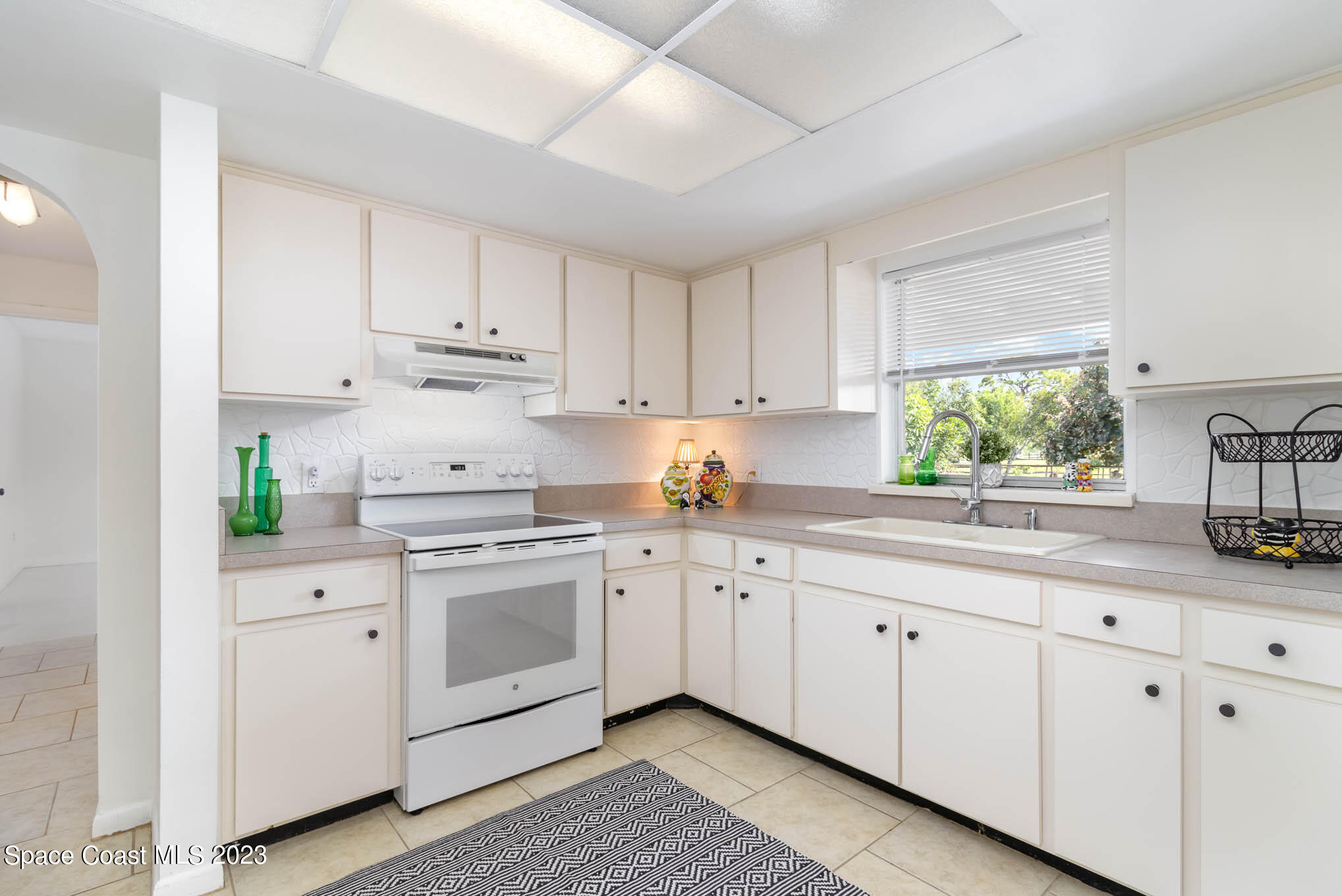 2095 Montgomery Road Melbourne, FL 32935 - Photo 9 of 25 a kitchen with white cabinets sink and window