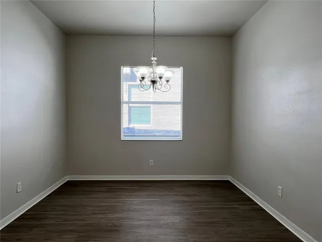 a view of a room with wooden floor chandelier and window
