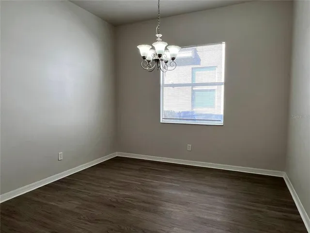 a view of a room with wooden floor and chandelier