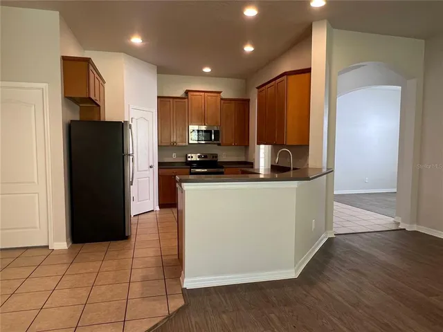 a kitchen with stainless steel appliances a refrigerator and a stove top oven