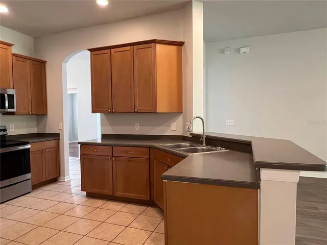 a kitchen with granite countertop a sink and a stove top oven