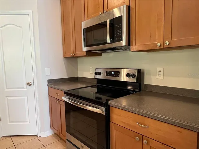 a kitchen with stainless steel appliances granite countertop white cabinets stove top oven and microwave