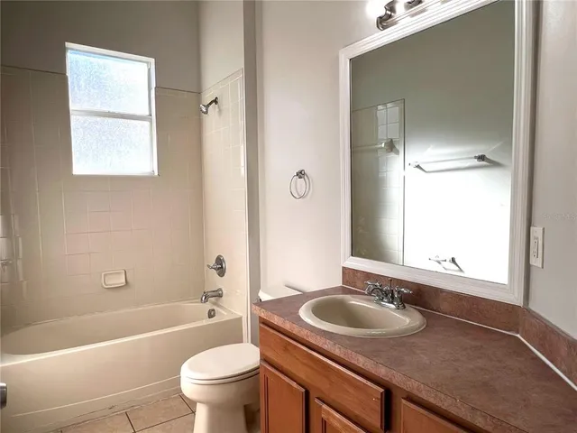 a bathroom with a granite countertop sink a toilet and a mirror