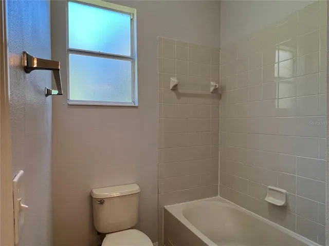 a white toilet sitting next to a bath tub