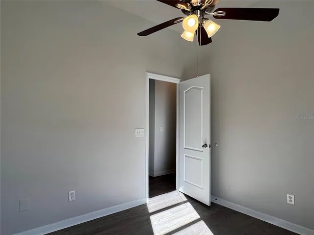 an empty room with closet and chandelier fan