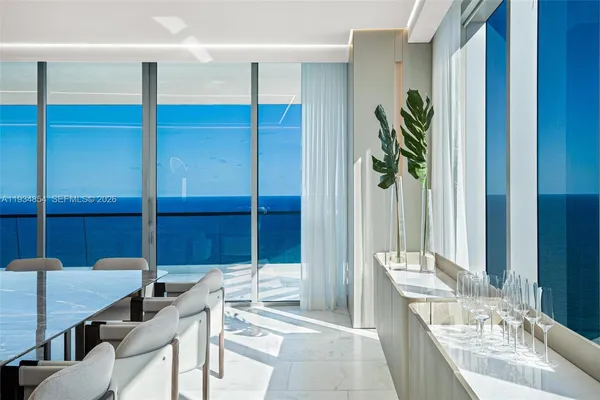 a kitchen with stainless steel appliances kitchen island granite countertop a table chairs sink and cabinets