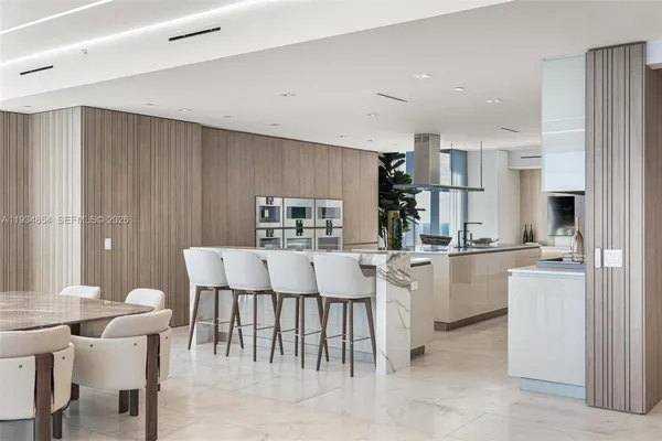 a living room with furniture a flat screen tv and kitchen view