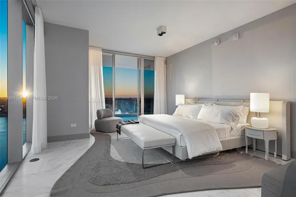 a view of a bedroom with a bed and a potted plant