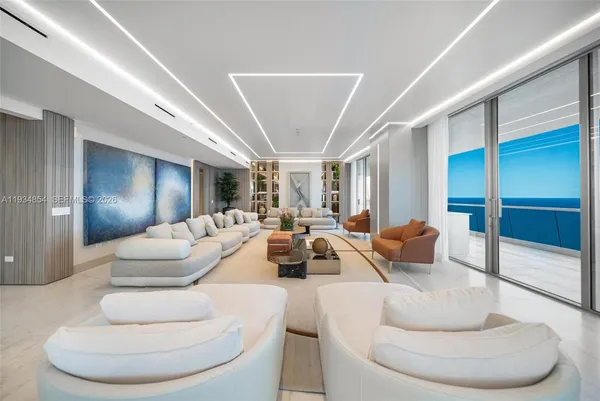 a living room with furniture a couch and a large window