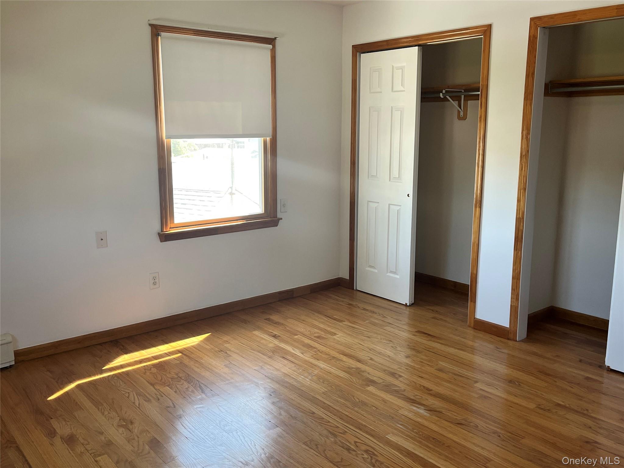 4278 Clarissa Road Bethpage, NY 11714 - Photo 2 of 9 Room featuring wood-finish flooring, white walls, and a window with a roller shade